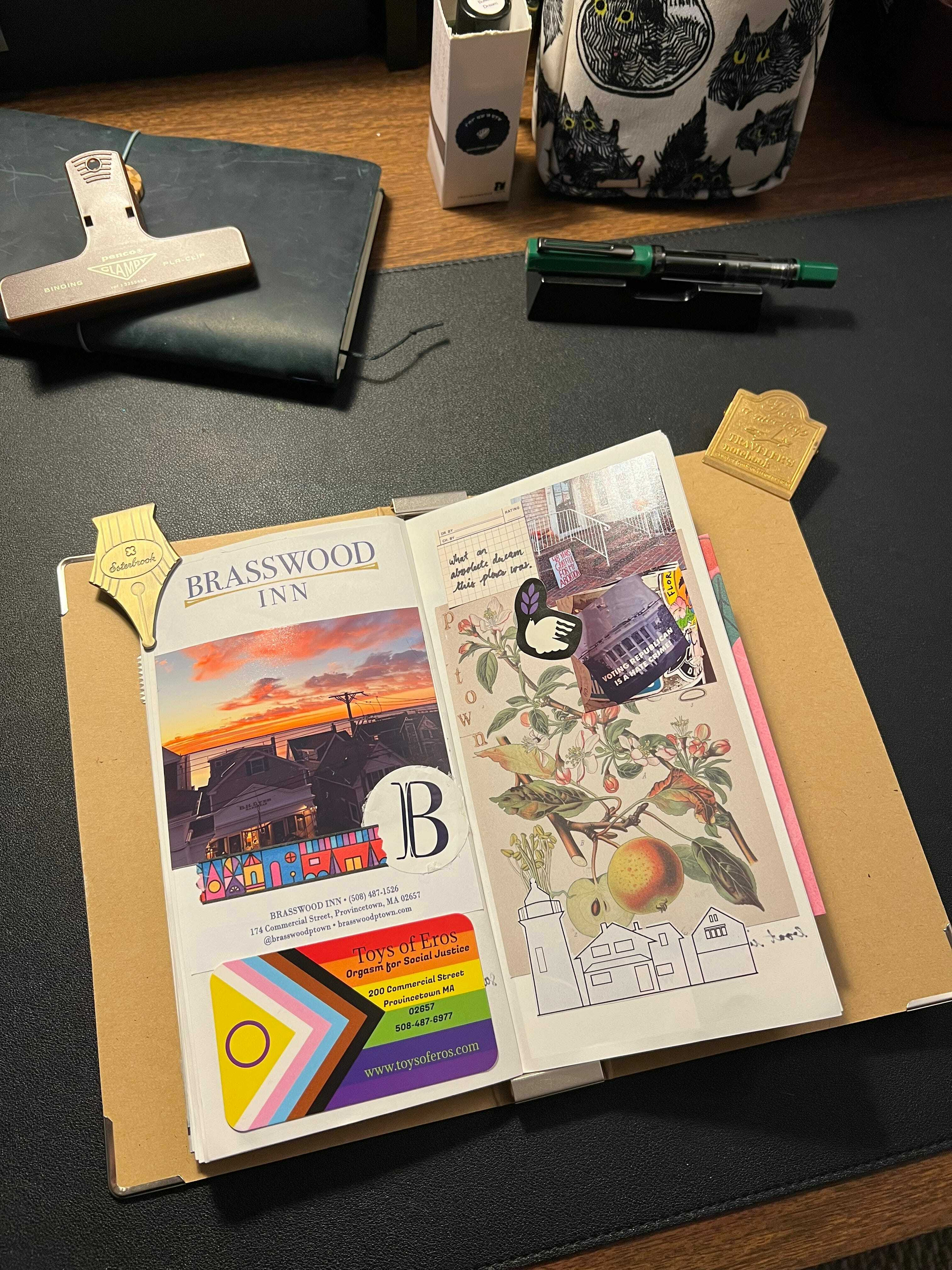 Auto-generated description: An open journal displays colorful brochures, stickers, and illustrations on a desk with various stationery items nearby.